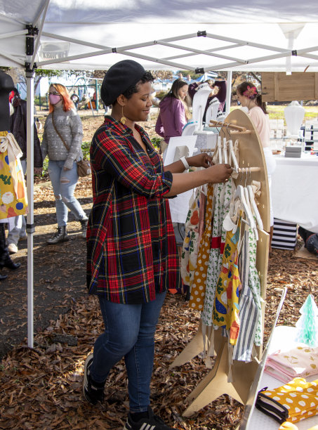 丹妮尔·马西斯，纺织和Twine家庭和生活方式品牌的所有者，安排围裙与她的原创设计在独立南部年度假日华友市场在雅典，格鲁吉亚图片下载