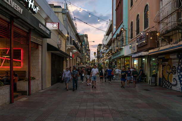 这是多米尼加共和国圣多明各殖民区一个户外购物中心的引人注目的图片，在黎明时分，街道和商店都亮起了灯。图片下载