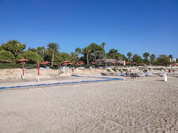 沙滩上的躺椅上有伞，躺椅上有山图片下载