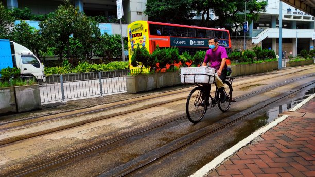 在香港金钟区，一名男子骑在电动火车线上图片下载