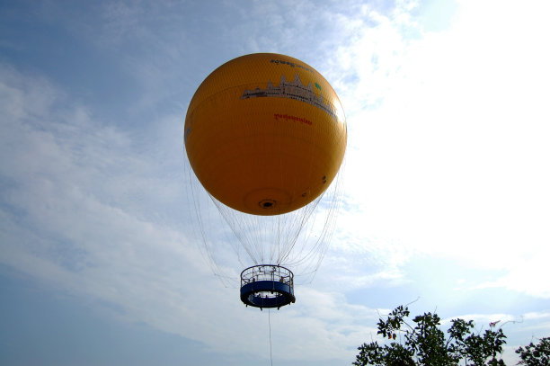 在柬埔寨暹粒，黄色气球在空中俯瞰吴哥窟和稻田图片下载
