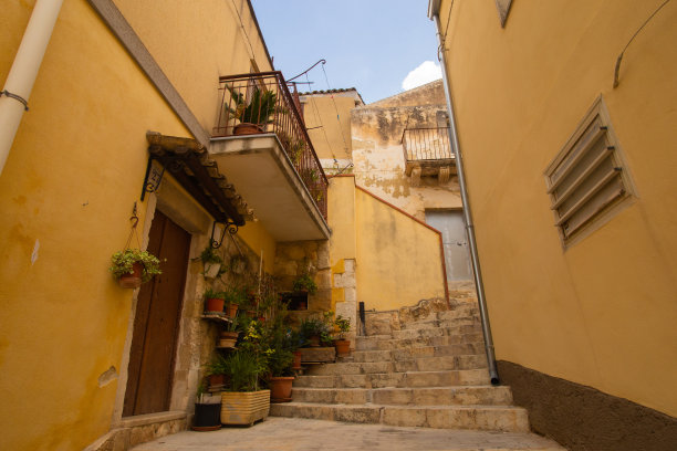 西西里莫迪卡古城的城市景观。砂岩房屋，楼梯和阳台，没有人在里面的庭院。明亮阳光的照片适合旅游小册子，旅游公司网站等。图片下载