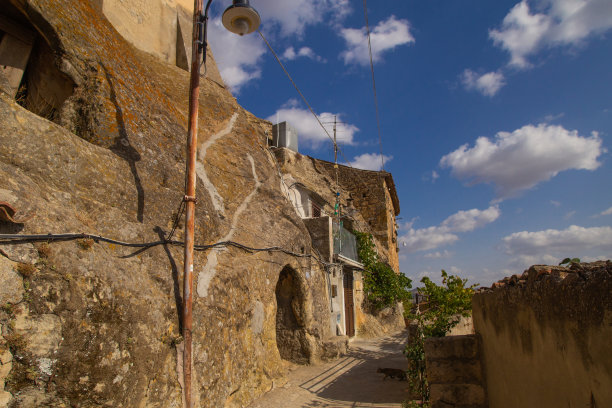 废弃的房子在岩石里，砂岩墙，拱门。意大利最美丽的波尔格酒之一。阳光照片适用于旅游旅行社宣传册、海报、广告。图片下载