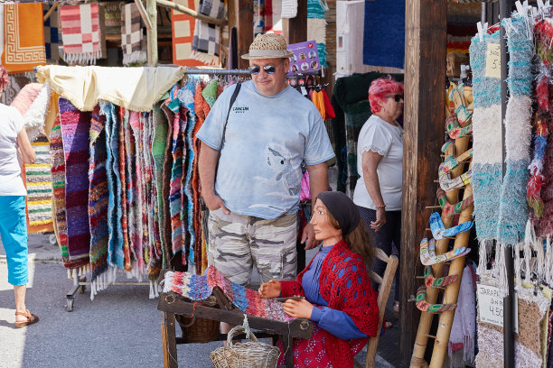 -游客选择传统手工纪念品、地毯、明信片和当地特产图片下载