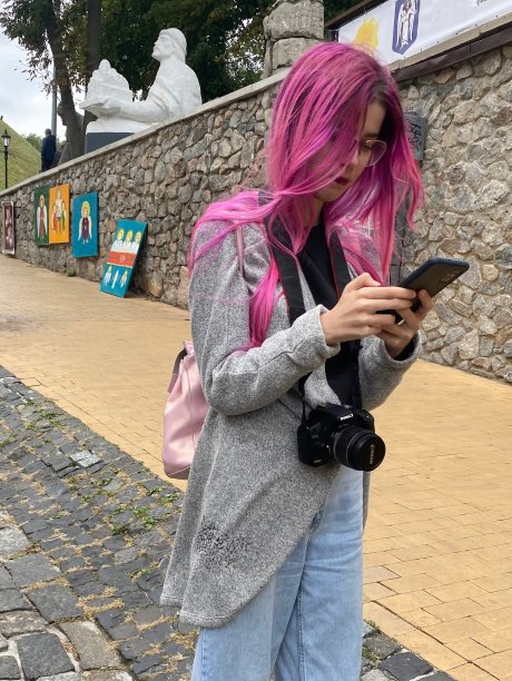 乌克兰基辅- 2021年10月:一名戴着眼镜、头发呈亮粉色的年轻漂亮女子在老城区拍摄风景照片。图片下载