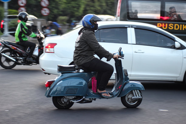 长曝光照片，两人骑着摩托车在下午通过万隆巴斯德地区的一个十字路口。图片下载
