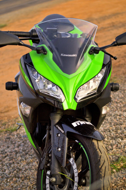 川崎忍者跑车停在公路上，背景是泥土。图片下载