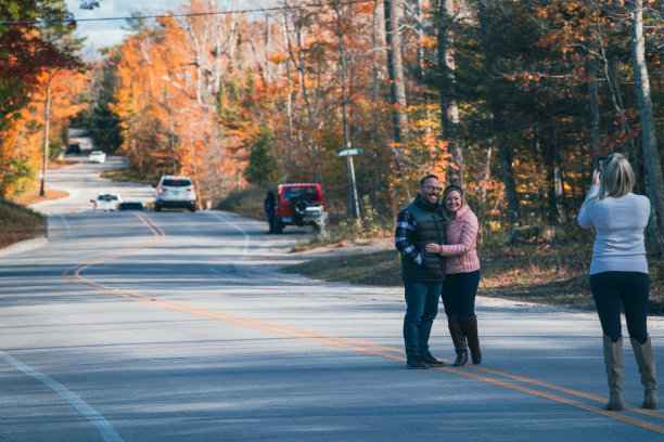 摄影师拍摄了一对幸福的夫妇在门县的弯曲路在秋天秋天在威斯康星州的照片图片下载