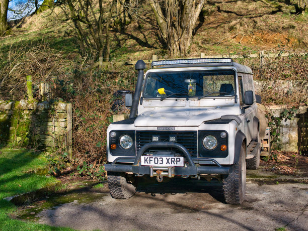 一辆白色的2003年路虎卫士配备了绞车，通气管和LED照明。这张照片拍摄于一个阳光明媚的冬日。图片下载