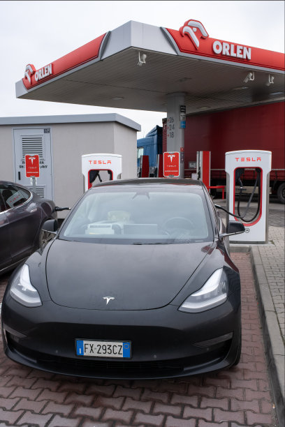 冬季在超级充电站充电的黑色特斯拉Model 3双电机长续航全轮驱动汽车的静态照片，选择性聚焦图片下载