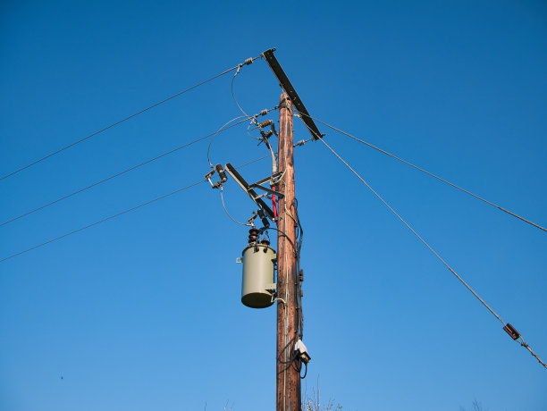 一个电力供应塔通过英国国家电网输送电力，显示电缆，隔离器和其他设备。这张照片拍摄于晴空万里的一天。图片下载