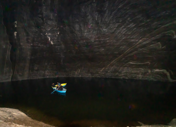 图尔达盐矿内部的照片，可以看到人们在被盐墙包围的湖上乘船图片下载