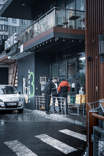 摩尔多瓦，基希讷乌——2022年1月23日麦当劳大道。麦当劳大道上汽车排起了长队。Glovo快递服务的员工正在等待订单的准备。艺术照片编辑。图片下载