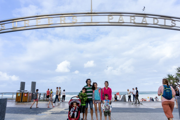 “冲浪者天堂”标志下的“家庭”代表“照片”，背景是海滩图片下载