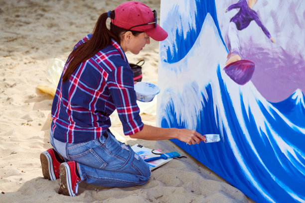女画家在木板上作画，画抽象画、彩画、户外节庆图片下载