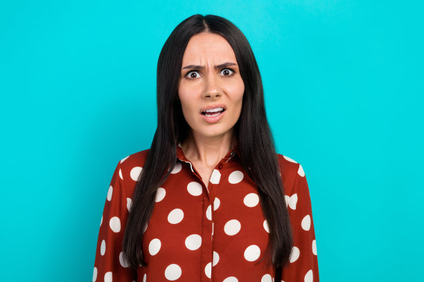照片不快乐的侵略性的黑发女人穿着红点衬衫，困惑的反应问题，失败者孤立在青色背景图片下载