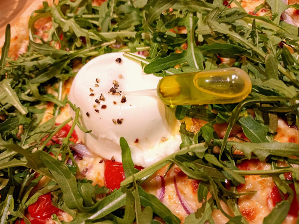 布拉塔奶酪和橄榄油在披萨上的特写照片图片下载