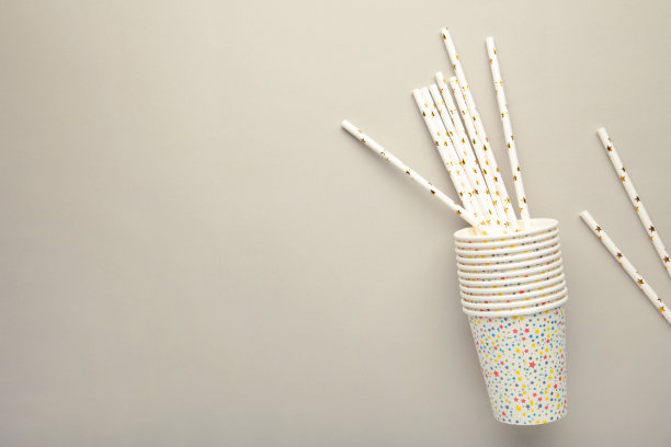 照片的杯子，鸡尾酒会管上的灰色背景与空白空间。图片下载