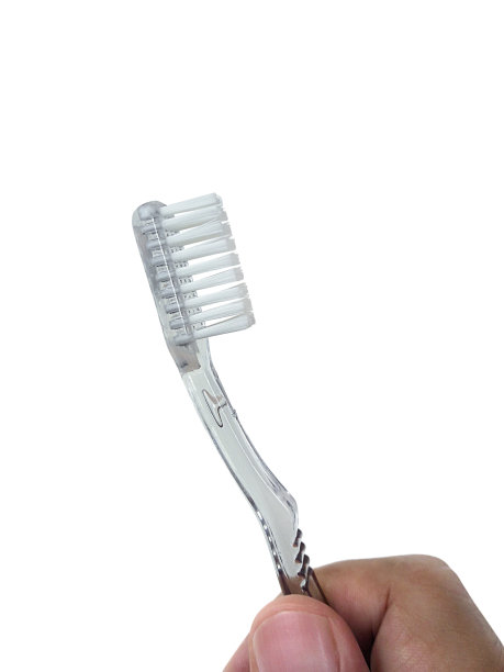 手拿着牙刷。白色背景的照片图片下载