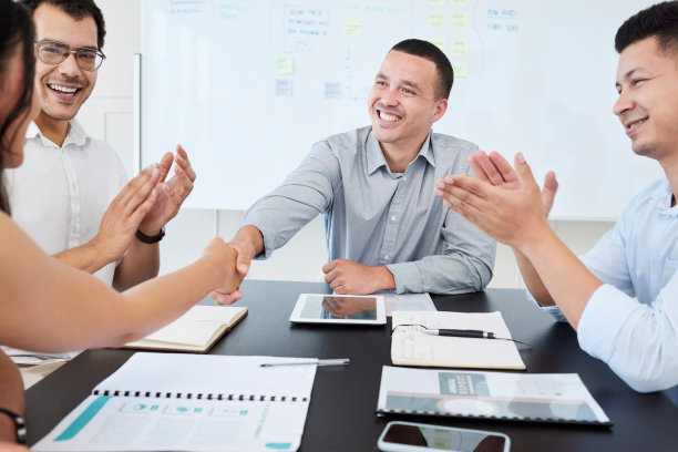 商务人士在办公室开会时握手的照片图片下载