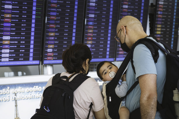 在素万那普机场检查起飞和抵达航班时刻表的外国家庭游客。新冠肺炎后，泰国重新开放旅游图片下载