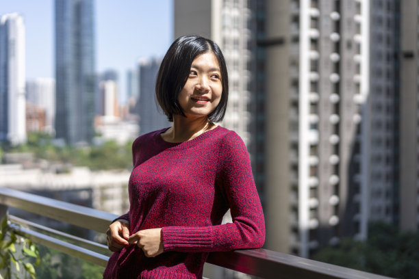 一位亚洲妇女在家里的阳台上望着远方图片下载