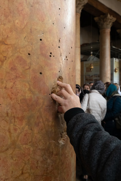 在以色列控制的巴勒斯坦伯利恒主诞教堂，游客将手指伸进石柱上的孔洞图片下载