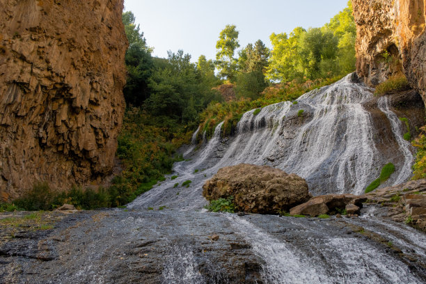 日木瀑布潺潺流水，景色如画，峡谷岩石间峡谷阳光灿烂。亚美尼亚库存图片图片下载