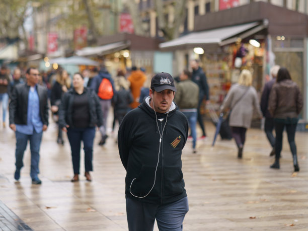 雨天走在巴塞罗那城市街道上的人们图片下载