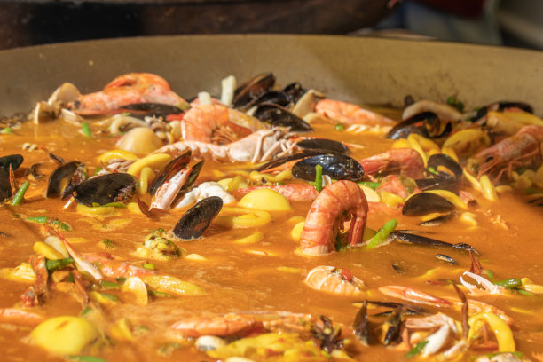 西班牙海鲜海鲜饭配米饭，豌豆，虾，蛤蜊，贻贝，鱿鱼，虾。街上的餐馆。有选择性的重点。高质量的照片图片下载