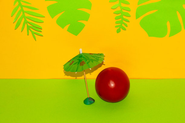 蕃茄伞下以黄绿色为背景，丛林绿叶为背景，创意热带健康设计图片下载