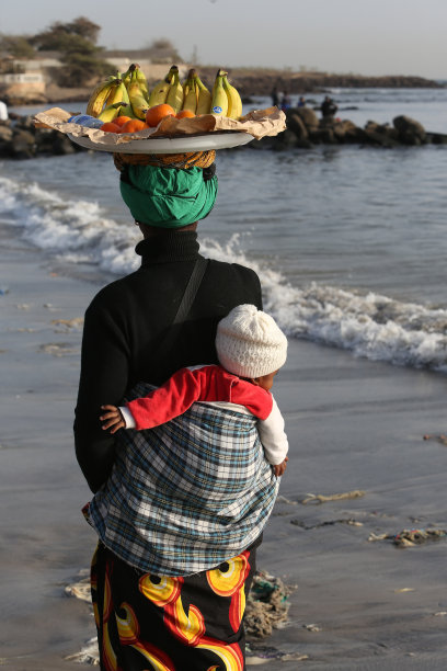 在塞内加尔达喀尔的松贝迪乌内市场，身着传统民族服装的女人，背着婴儿图片下载