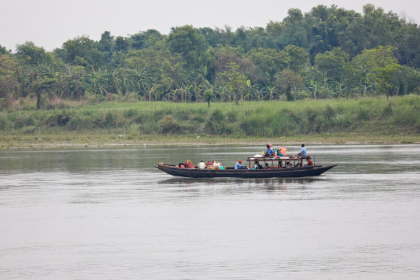 2021年，西孟加拉邦洪水泛滥——乡村被淹没，当地人乘坐木船过河图片下载