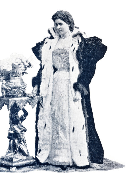 巴黎时装，天鹅绒晚礼服，模特站在一个小花桌全长图片下载