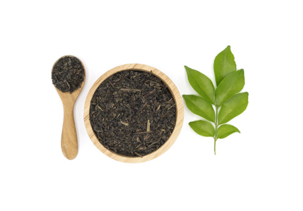 干燥的绿茶茶叶在木勺和碗与茶叶孤立在白色的背景。顶视图的照片。图片下载