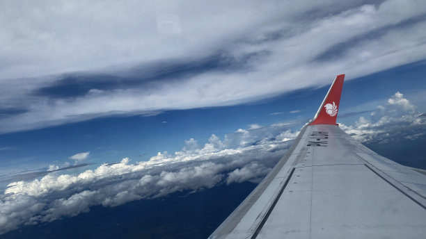 雅加达上空的飞机机翼和云层的全景飞行照片，2022年6月图片下载