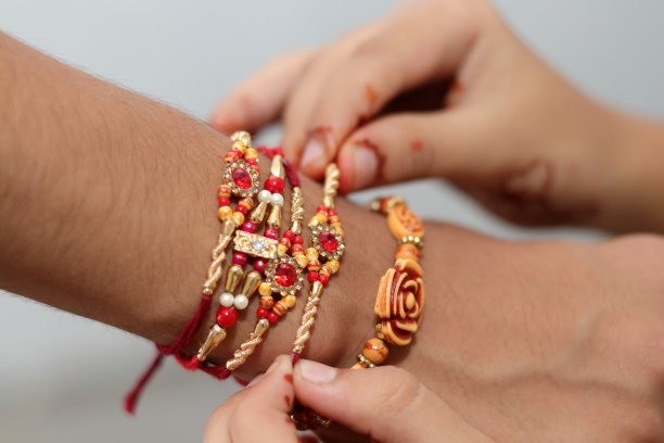 在罗吉节上，女孩的手以不同的角度把罗吉绑在男孩的手上。图片下载