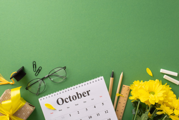 拥抱教师节庆祝活动!俯视图照片展示日历，学校用品，菊花花束和礼盒在黑板孤立的背景。用于广告或文本的复制空间图片下载