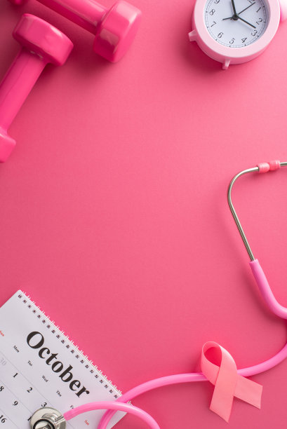 乳腺癌慈善募捐者。医生设备的垂直俯视图照片，适合筛选，日历，粉红丝带，听诊器，哑铃，闹钟在粉红色的背景，广告的空间图片下载