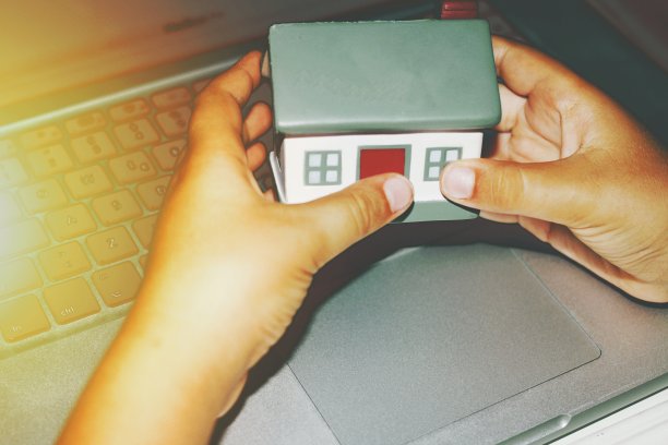 用两只手握住房屋模型。概念上的照片。图片下载