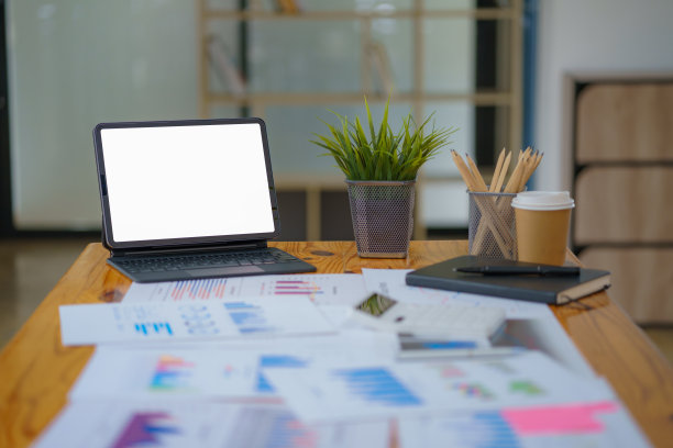 特写图片，便携式数字平板电脑触摸板白色屏幕模拟站与无线键盘在办公桌上。图片下载