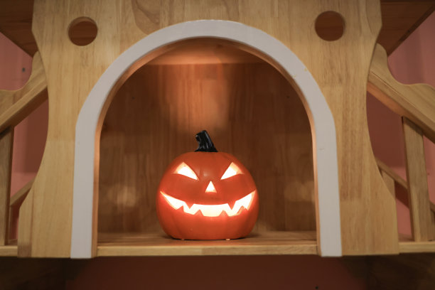 万圣节可爱的小猫和雕刻南瓜。万圣节插图与可爱的姜黄色小猫和有趣的南瓜在最小的背景与复制空间图片下载