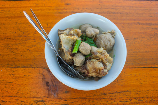 木桌上白色的碗里盛着肉丸汤。图片下载