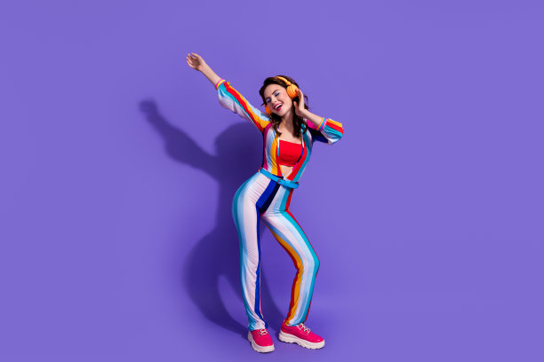 照片开朗积极的女士音乐爱好者使用听立体声耳机孤立的紫色背景图片下载