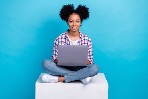 正面甜美的女士穿着格子衬衫的全长照片在线学习现代设备孤立的蓝色背景图片下载