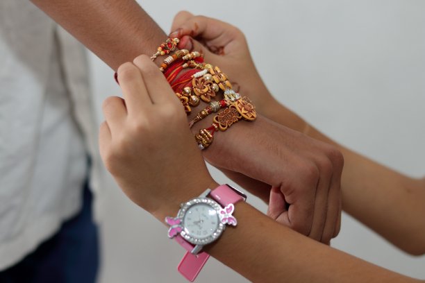 在罗吉节上，女孩的手以不同的角度把罗吉绑在男孩的手上。图片下载