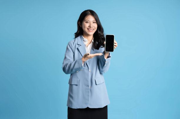 蓝色背景的年轻女商人使用手机的图片图片下载