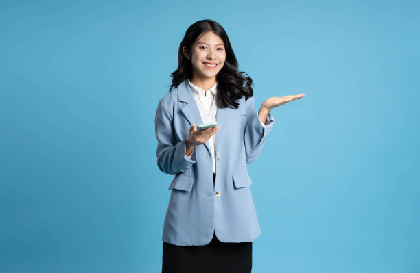 蓝色背景的年轻女商人使用手机的图片图片下载