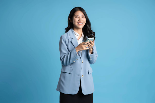 蓝色背景的年轻女商人使用手机的图片图片下载