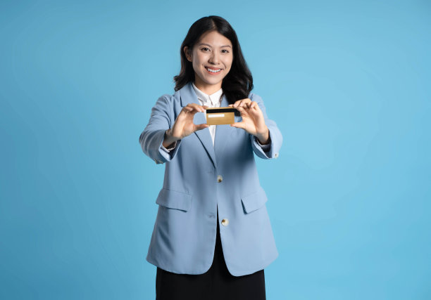 蓝色背景的亚洲女商人手持银行卡的图片图片下载